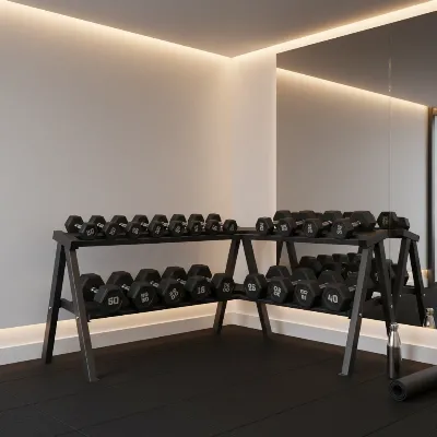 A well-organized rubber dumbbell set stored on a rack in a clean home gym.